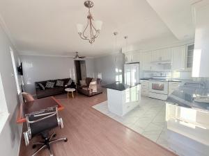 eine Küche und ein Wohnzimmer mit Sofa und Tisch in der Unterkunft Super 8 by Wyndham Salmon Arm in Salmon Arm