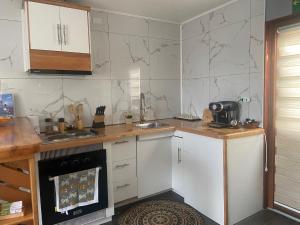 uma cozinha com armários brancos e uma bancada em Cabañas Bosque Austral em Punta Arenas