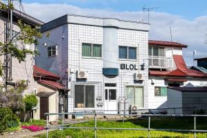 a white building with a sign on it at lol 3 101 in Hakodate