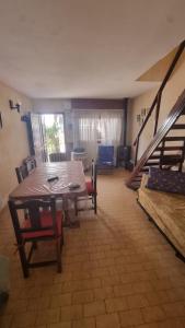 a living room with a table and chairs and a staircase at Duplex familiar 3 ambientes in San Bernardo
