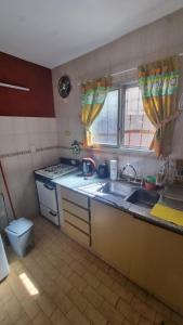 a kitchen with a sink and two windows in it at Duplex familiar 3 ambientes in San Bernardo +4 photos