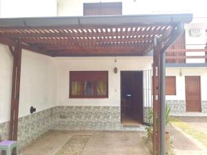 a house with a wooden pergola and a door at Duplex familiar 3 ambientes in San Bernardo
