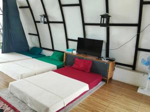 a room with two beds and a tv in it at Villa Eriyana in Ciater