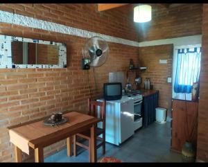 a kitchen with a white refrigerator and a small table at Mono Complejo Cóndor in Mina Clavero