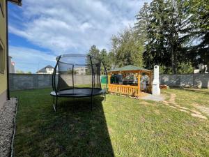 ein schwarzer Stuhl steht in einem Garten mit einem Pavillon in der Unterkunft Heliolit in Dudince