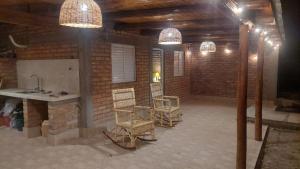 a room with two chairs and a kitchen with lights at Casa de Amaicha in Amaicha del Valle