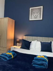 a bedroom with a large bed with blue walls at Doncaster Penthouse Long Stays in Doncaster