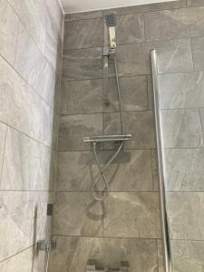 a shower with a hose in a bathroom with a tile floor at Doncaster Penthouse Long Stays in Doncaster +18 photos
