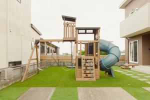 a playground with a slide on a lawn at Lapacho 子どもが絶対満足する宿 民泊らぱちょ in Kumamoto