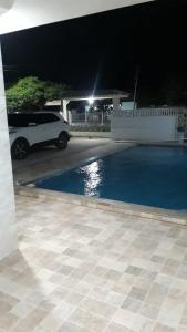 a white car parked in a driveway at night at Hotel cabana in Magalhães Bastos