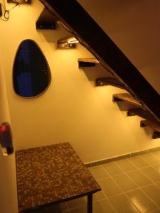 a room with a staircase with a bench and a window at Guaecá Hostel - Cumuruxatiba in Cumuruxatiba