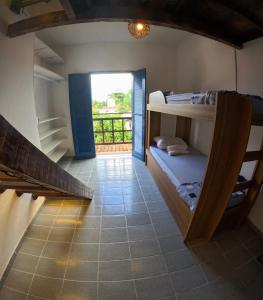 a room with bunk beds and a hallway with a window at Guaecá Hostel - Cumuruxatiba in Cumuruxatiba
