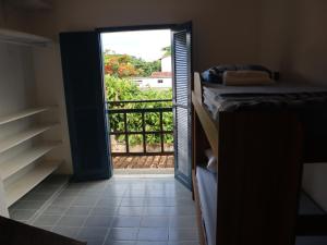 a room with a door open to a balcony at Guaecá Hostel - Cumuruxatiba in Cumuruxatiba