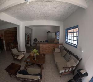 a living room with a couch and a table at Guaecá Hostel - Cumuruxatiba in Cumuruxatiba
