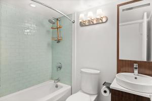 Un baño con un inodoro blanco y un lavabo. en Chateau Dumont Unit 21, Fully Renovated Top Floor Condo, Downtown Aspen, Panoramic Mountain Views, en Aspen 8 fotos más