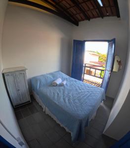 a small bedroom with a bed and a window at Guaecá Hostel - Cumuruxatiba in Cumuruxatiba