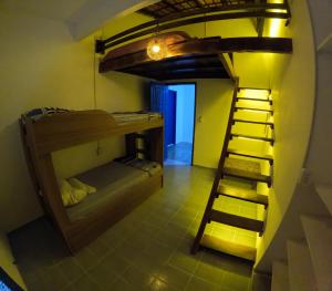 a room with a bunk bed with a ladder at Guaecá Hostel - Cumuruxatiba in Cumuruxatiba
