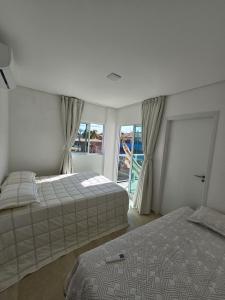 a bedroom with two beds and a window at Casa Beira Mar com Piscina Maragogi - Amar & Mar in Maragogi +61 photos