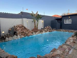 - une piscine d'eau bleue et de rochers dans l'établissement De Hill Leisure Guest House, à Johannesbourg