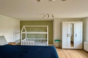 - une chambre avec un lit bleu et un placard blanc dans l'établissement Ferienhaus Havelzeit in Werder an der Havel, à Glindow