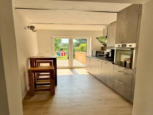 une cuisine avec des appareils en acier inoxydable et une table dans l'établissement Ferienhaus Havelzeit in Werder an der Havel, à Glindow