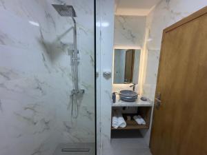 a bathroom with a shower with a glass door at LogiHomeMorocco in Agadir +7 photos