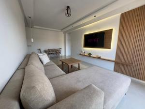 a living room with a couch and a tv at LogiHomeMorocco in Agadir