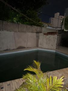 Una piscina en un patio trasero por la noche. en Suites em mansão, en Fortaleza