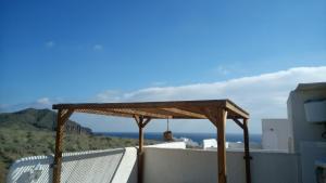 weranda z drewnianym dachem, krzesłem i widokiem na ocean w obiekcie Isleta del Moro TERRAZA VISTAS MAR Exclusiva 60 m2 WIFI w mieście La Isleta del Moro