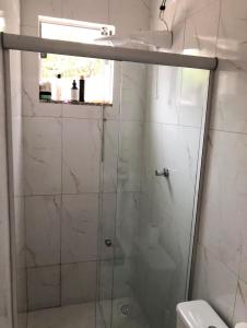 a shower with a glass door in a bathroom at Casa Donna Flor 2 Quartos Completa Centrinho com Garagem Coberta in Catas Altas