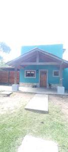 ein blaues Haus mit einem Rasenplatz davor in der Unterkunft Casa en pinamar in Pinamar