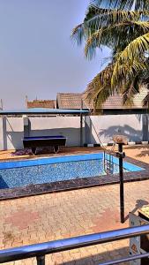 una piscina di fronte a una casa con pianoforte di Annabelle & Annabelle Apartment ad Abeokuta