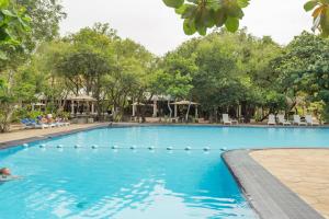 a pool at a resort with a person swimming at Nilaveli Beach Hotel in Nilaveli