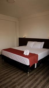 a bedroom with a large bed with a towel on it at Rivo Ohia Inn in Rioja