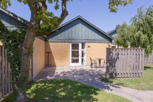 a house with a fence and a table in a yard at Hotel Balka Strand in Neksø