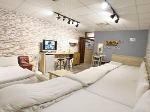 a room with a row of white beds in it at 近 距離 in Taichung