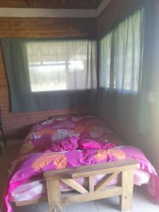a bed with a wooden bench in a room at Cabañas Lo De Elias in San Lorenzo