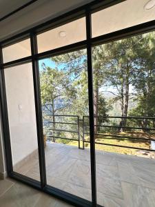 Aussicht von der Innenseite eines Hauses mit Glasschiebetüren in der Unterkunft Casa Madera 2A in Zacatlán