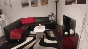 ein Wohnzimmer mit schwarzem Sofa und Fernseher in der Unterkunft rirodi01 in Gelsenkirchen