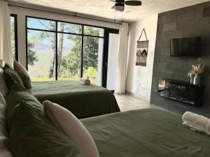 a bedroom with two green beds and a tv at Casa Madera 1B in Zacatlán