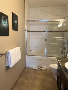 a bathroom with a shower and a toilet and a tub at The Moorage - Luxury 2 bed & 2 bath Condo on Marina in Ucluelet +10 photos