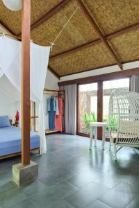 a bedroom with a bed and a table in a room at Pool House Studios in Kuta Lombok