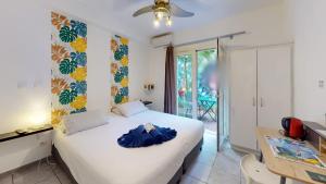 a bedroom with a bed with blue robes on it at Lindsey Hôtel in Saint-Pierre +79 photos