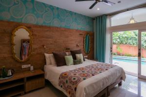 a bedroom with a large bed and a mirror at Pesona Beach Resort & Spa - Adults Only in Gili Trawangan