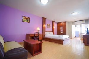 a bedroom with purple walls and a bed and a couch at Green Beach Pattaya in Pattaya North +94 photos