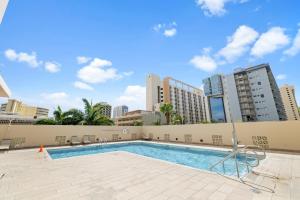 a swimming pool with buildings in the background at Royal Kuhio 1812 - 1BR with partial ocean view in the Heart of Waikiki with Free Parking! in Honolulu
