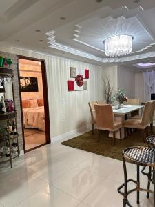 a dining room with a table and a bedroom at Apartamento moderno em Miguel Pereira in Miguel Pereira
