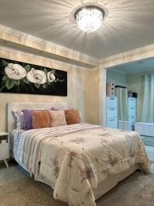 a bedroom with a large bed and a chandelier at Apartamento moderno em Miguel Pereira in Miguel Pereira