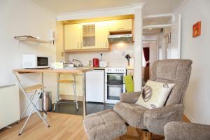 66D South Snowdon Wharf في بورثمادوج: مطبخ مع طاولة وكرسيين ومكتب