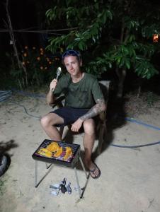 a man sitting in a chair with a microphone at Bangkaew Camping place bangalow in Krabi town